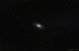 This lonely galaxy is obscurred by a dark band of dust.